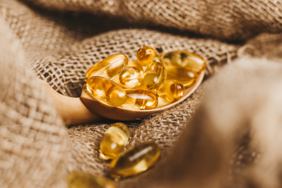 fish oil supplements on a wooden spoon