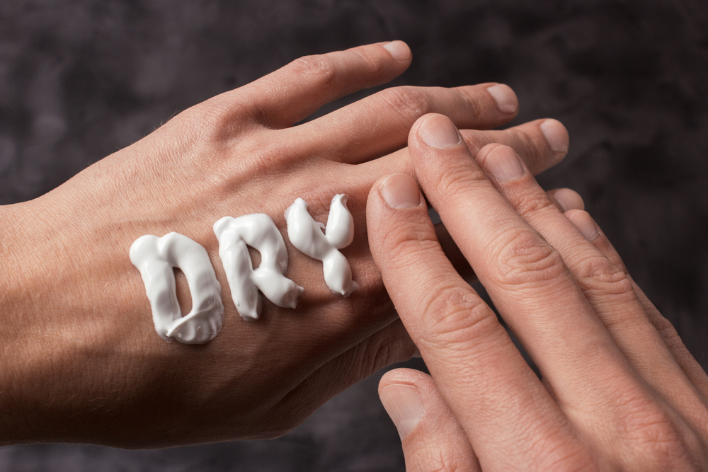 word "dry" spelled out with moisturizing lotion on hand