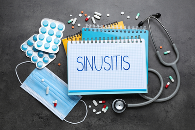 sinusitis written on a notepad surrounded by medicine and doctor equipment