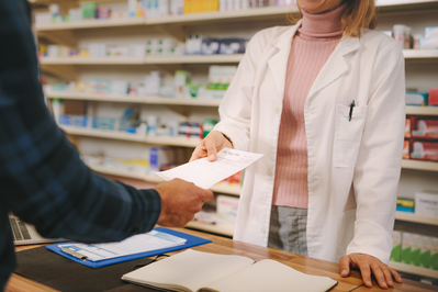 pharmacist helping a patient with a prescription refill