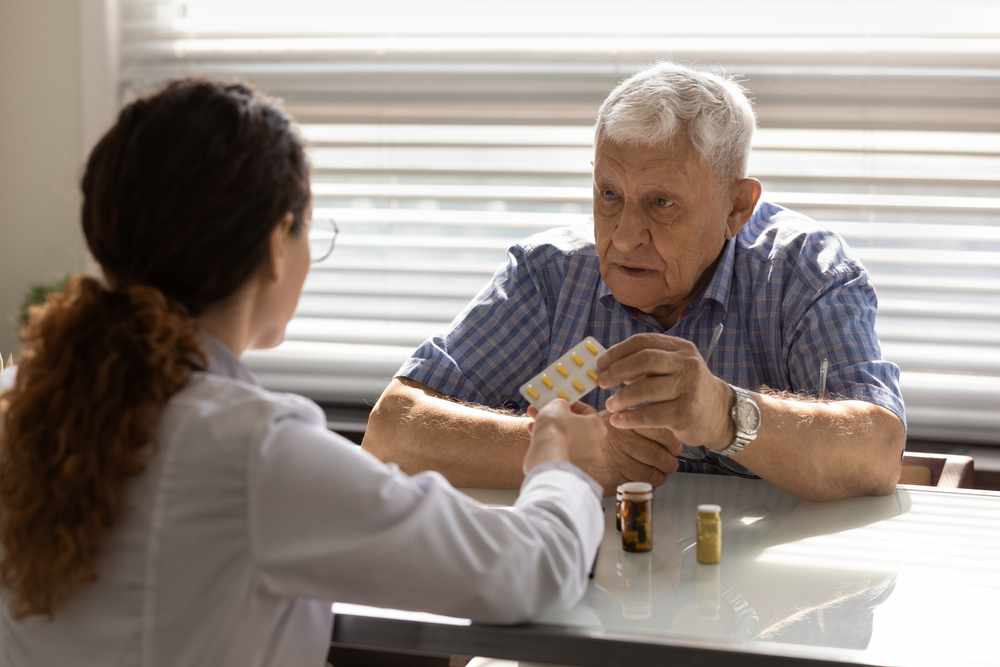 pharmacist explaining medications to older patient during health consultation