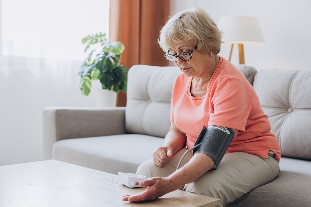 senior woman measuring blood pressure at home